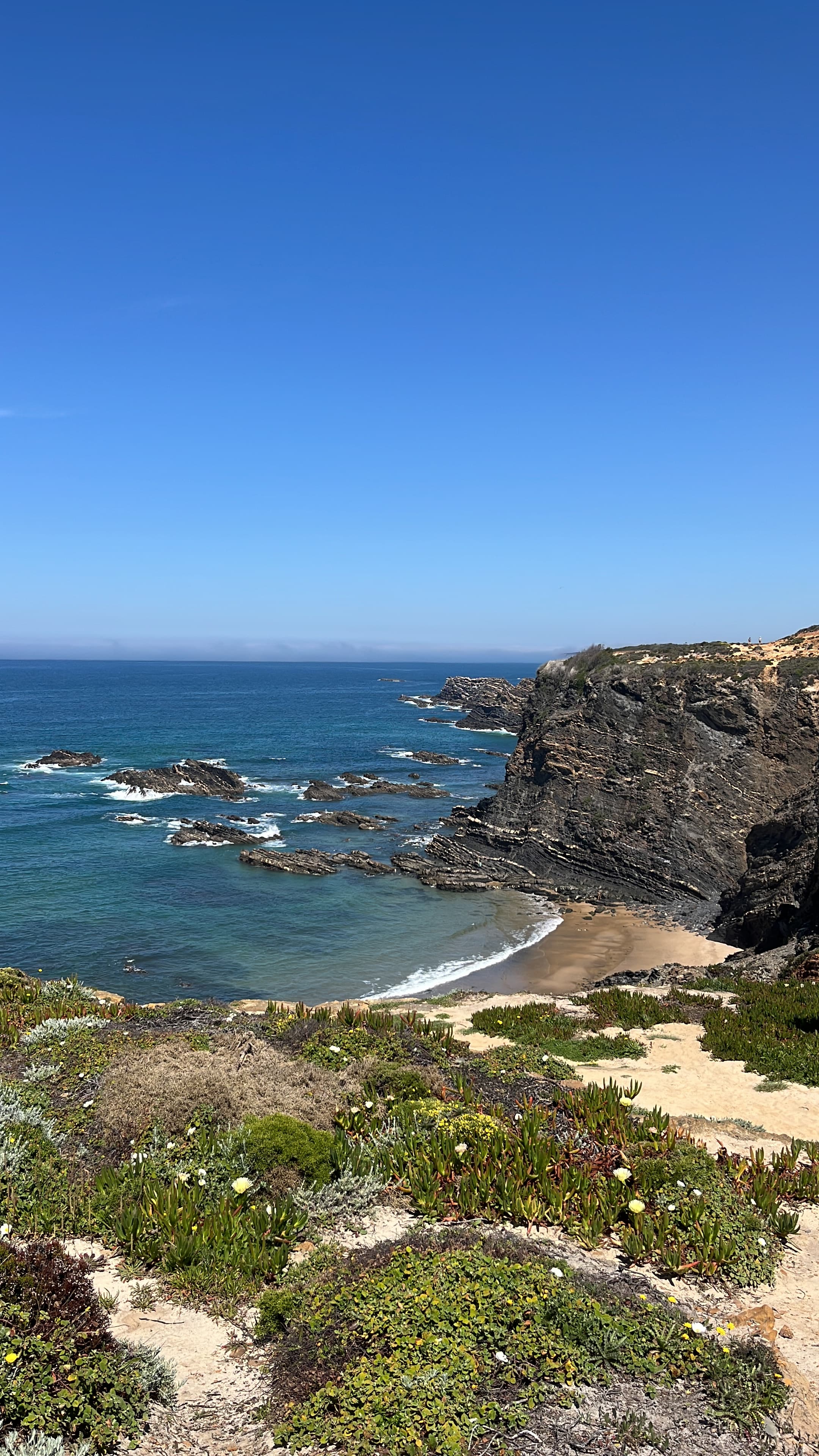 Sunlit cove with layered cliffs and turquoise water